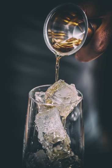 Bartender pouring alcohol in glass, close up shot